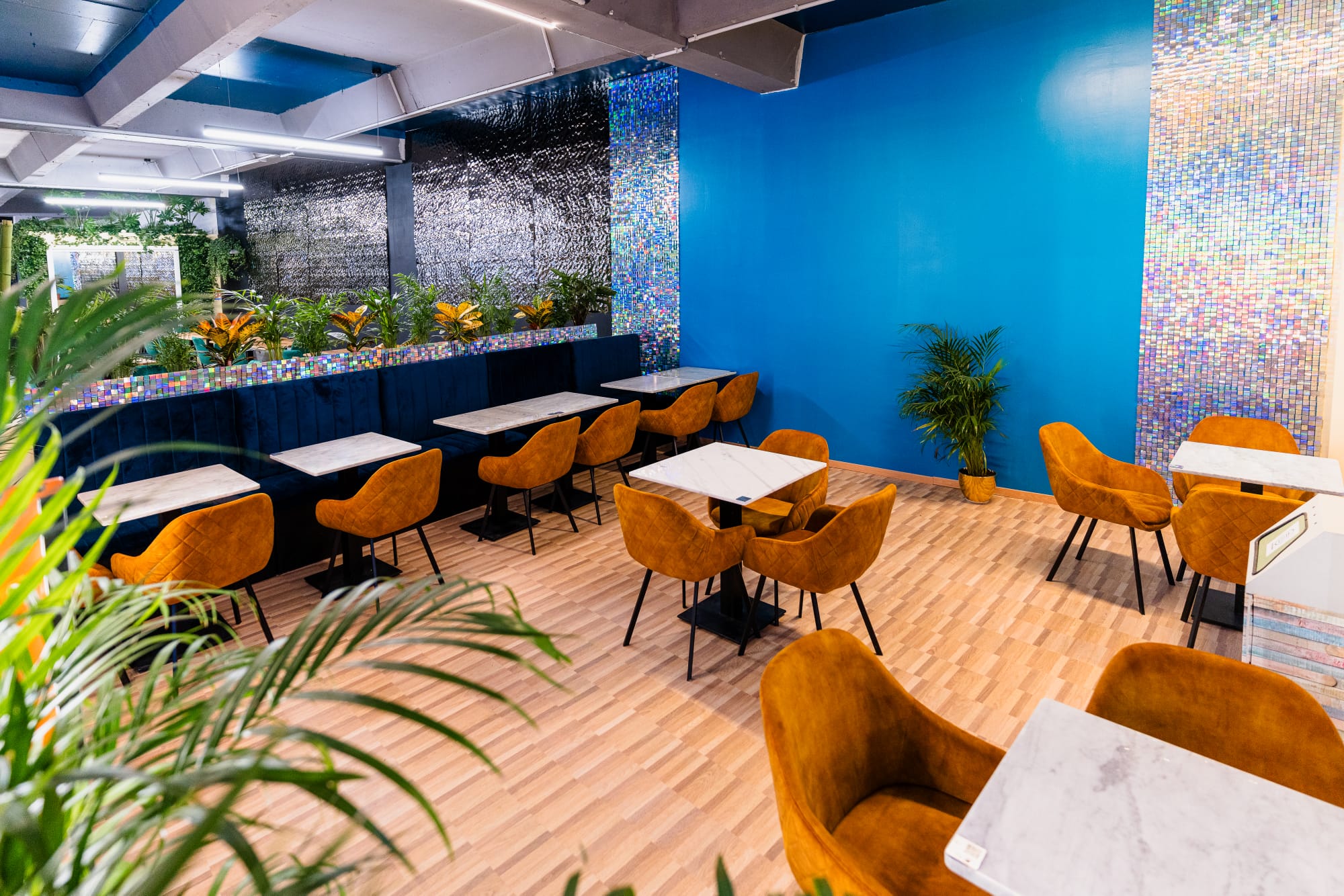 Salle du restaurant H2O Metz avec banquettes bleues et mosaïques iridescentes